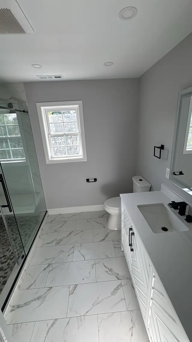 Bathroom view with a tiled floor, vanity, and glass shower enclosure.