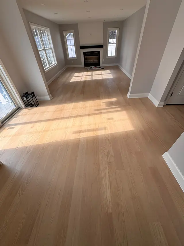 Wood-look flooring through a living area toward a fireplace.