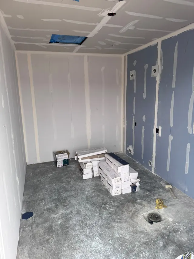 Bathroom walls and ceiling during drywall preparation, before tile installation.