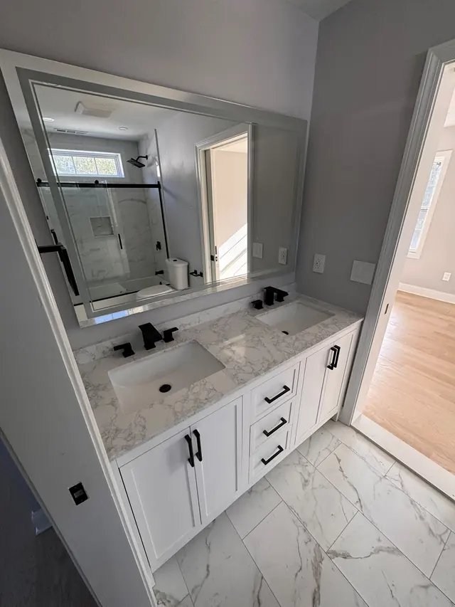 Another view of the bathroom double vanity and tiled floor.