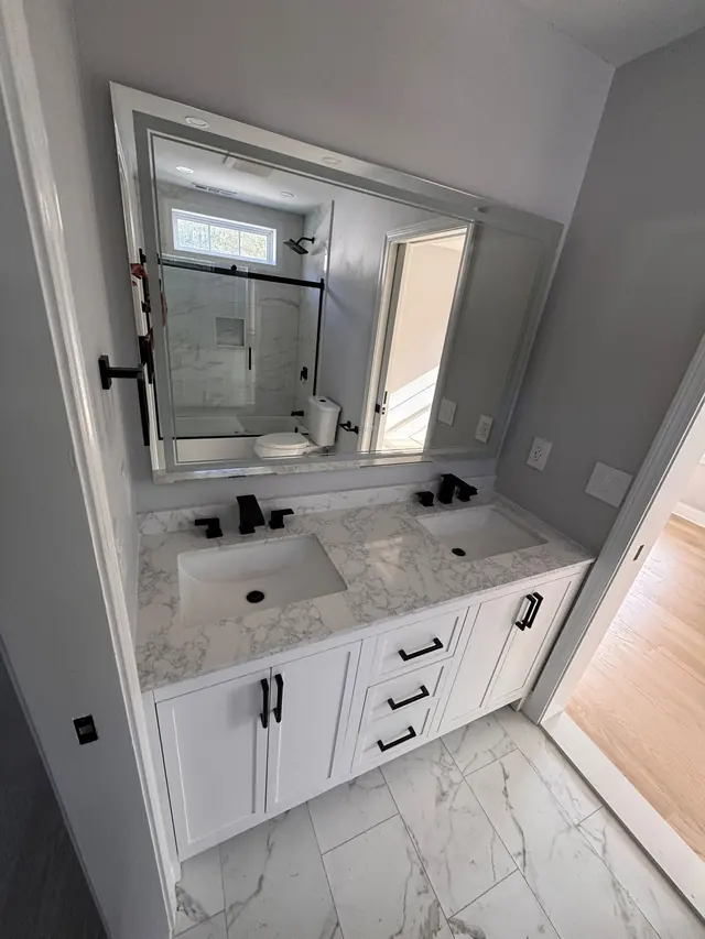 A bathroom double vanity, mirror, and tiled floor.